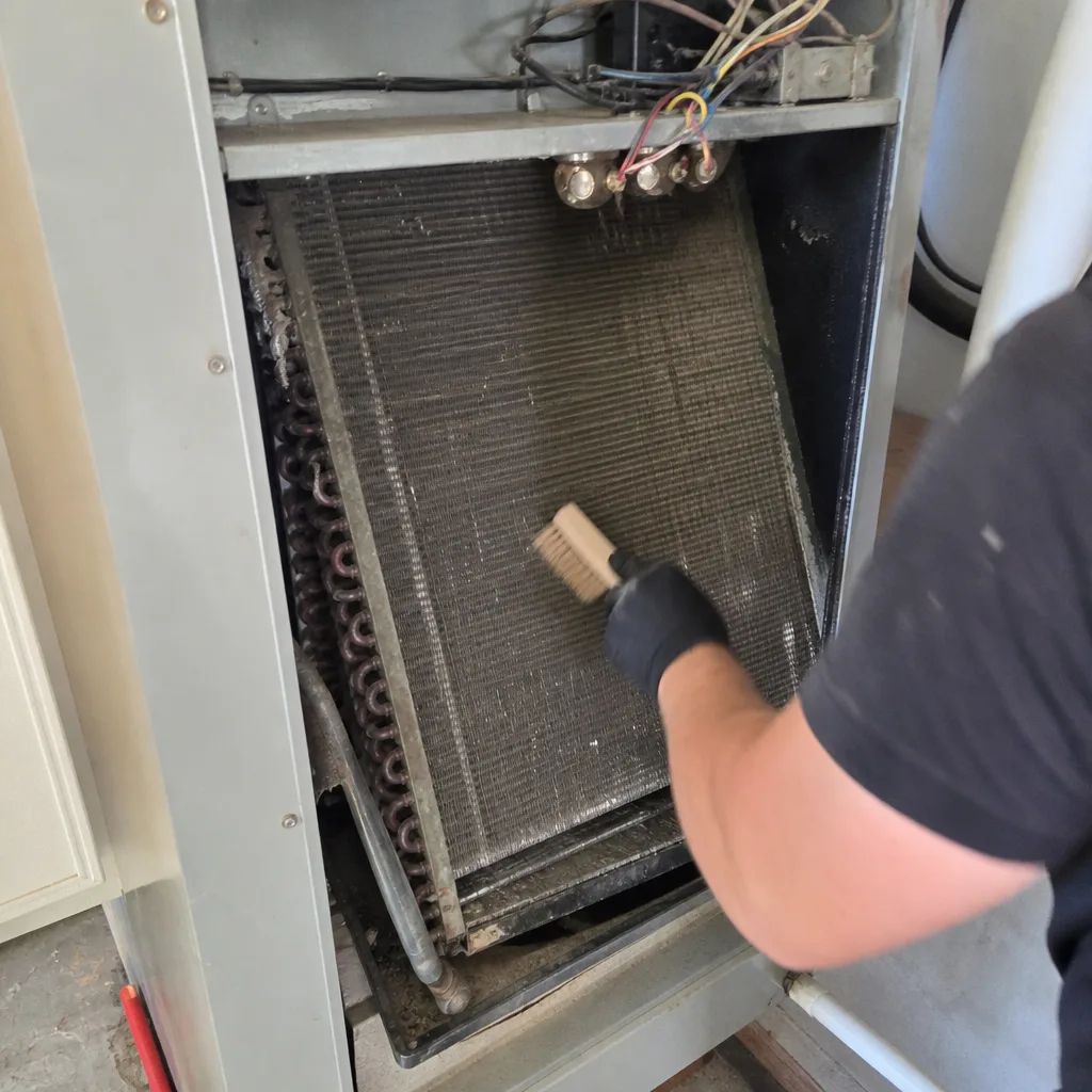 Technician performing professional HVAC coil cleaning and maintenance